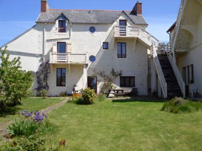 una gran casa blanca con un patio de césped en Les Hortensias GR 34 - Chambres d'Hôtes en Trévou-Tréguignec