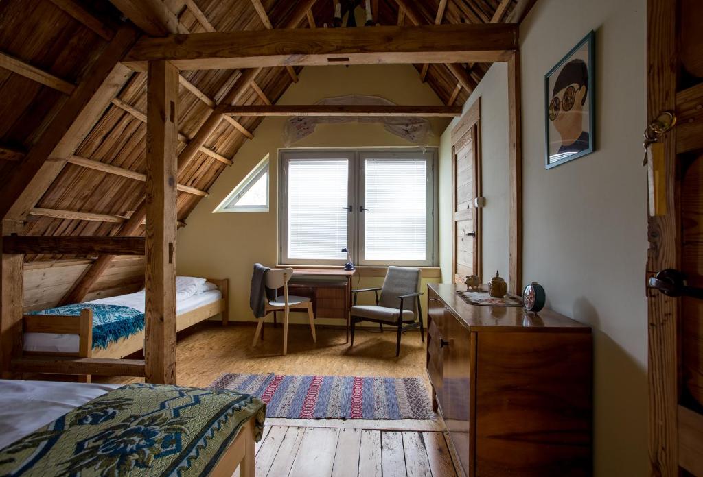 een slaapkamer met een bureau, een bed en een raam bij MorzeLas niebieski domek in Białowieża