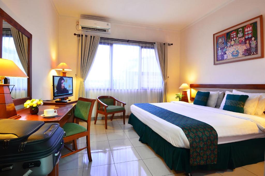 Postel nebo postele na pokoji v ubytování Griya Sentana Hotel