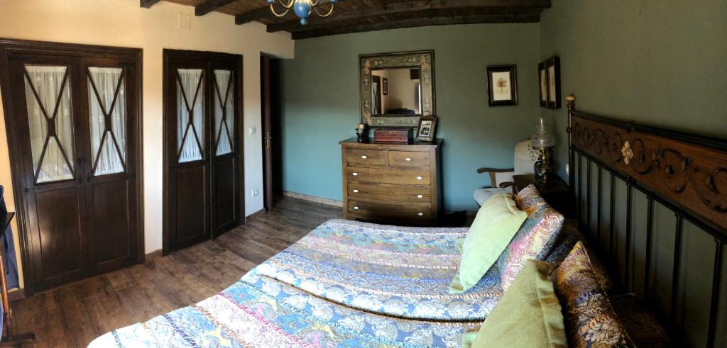 a bedroom with a bed with a dresser and a mirror at Gran Pedroso de Llanes in Llanes