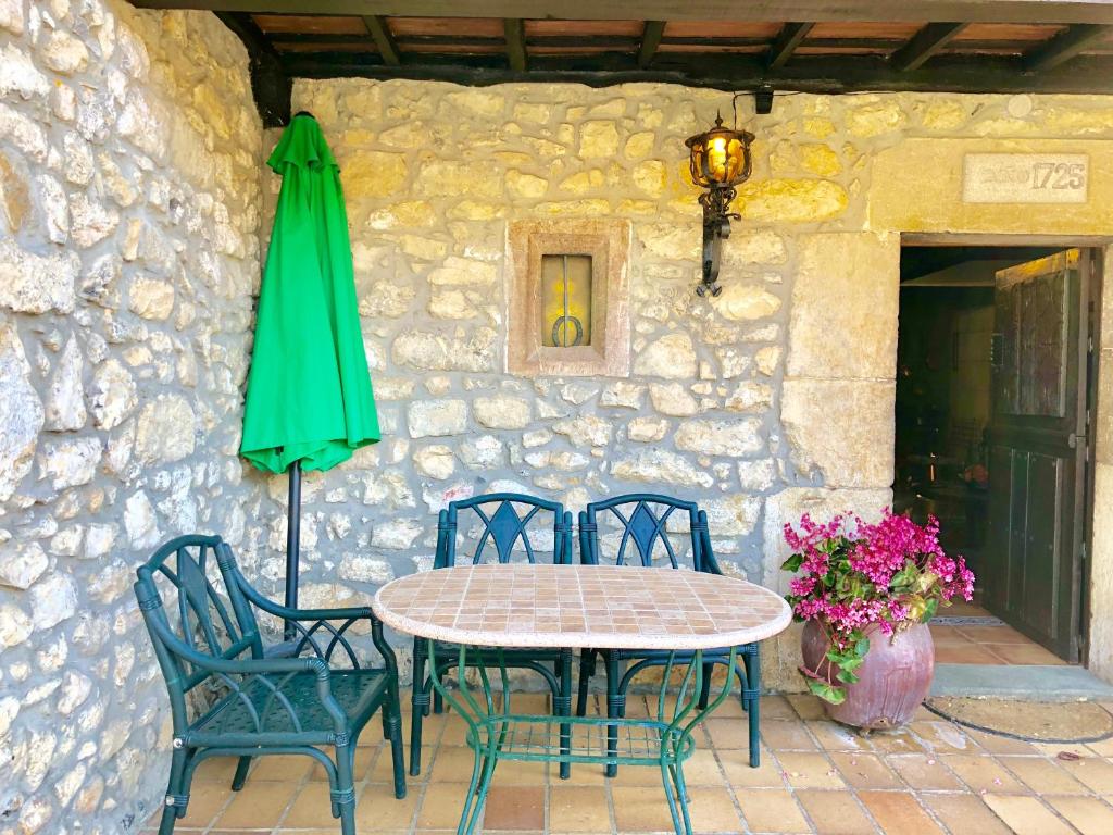 a table and chairs and a green umbrella on a patio at Gran Pedroso de Llanes in Llanes