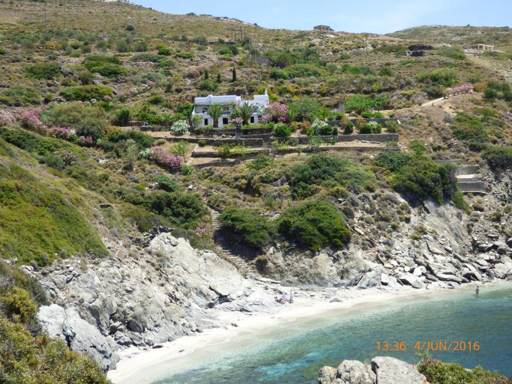 ein Haus auf einer Klippe neben einem Strand in der Unterkunft Exclusive Beach House in Gavrio
