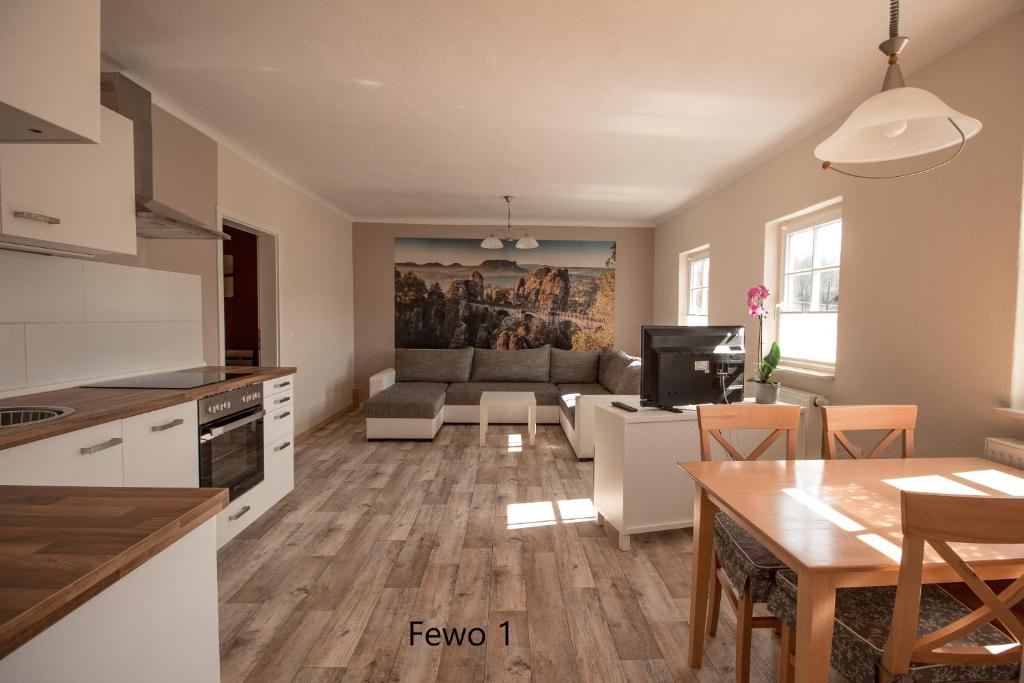een keuken en een woonkamer met een tafel bij Ferienhof Cunnersdorf in Kurort Gohrisch