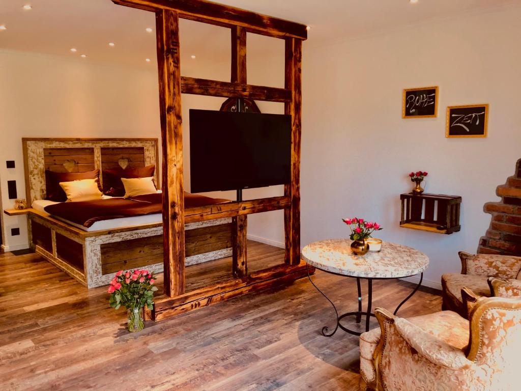 sala de estar con cama grande de madera y TV en Gästehaus Annel, en Niederhorbach