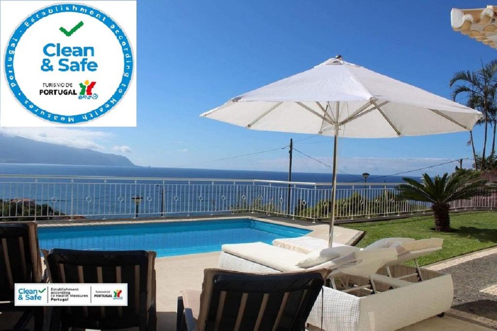 basen z parasolem i krzesłami obok basenu w obiekcie Villa Quinze - Luxurious 3 bedroom Villa with private pool and games room & amazing views w mieście Ponta Delgada