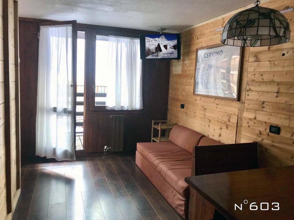 a living room with a couch and a table at House Cervinia Apartments in Breuil-Cervinia