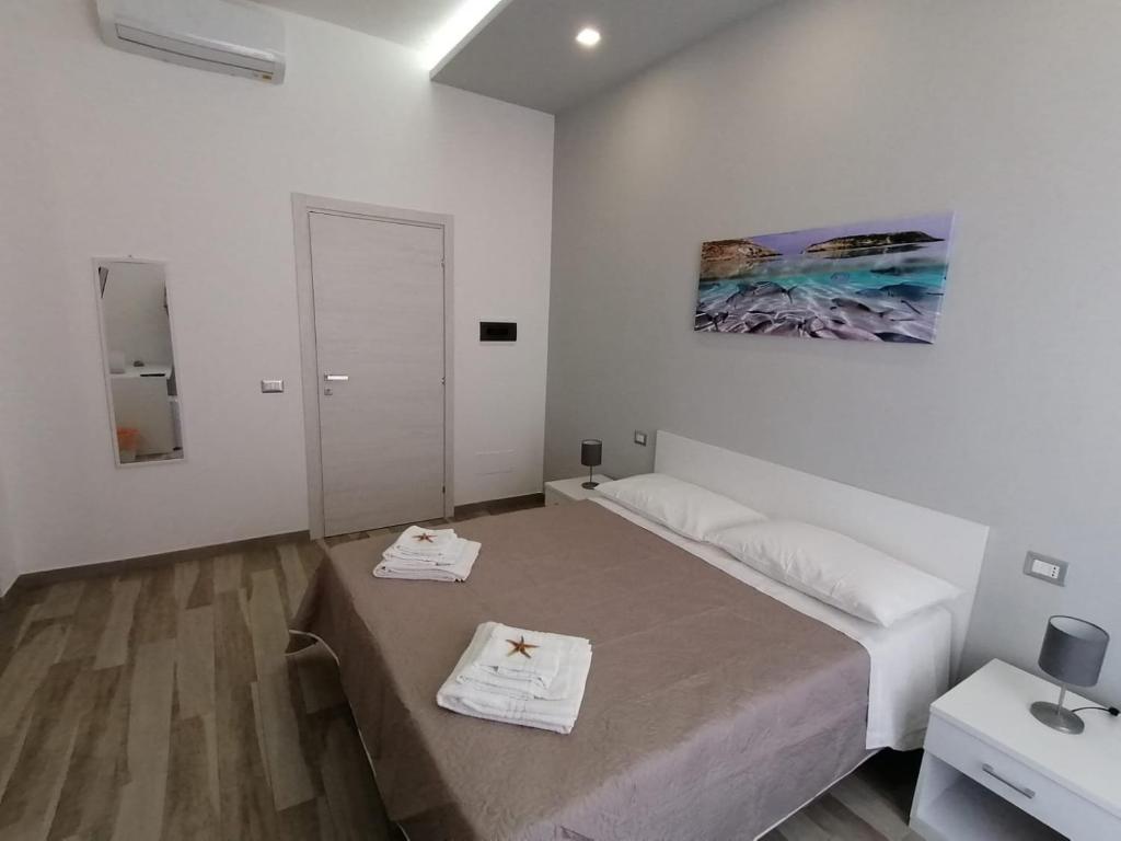 a white room with a bed with two towels on it at B&B La Casa di Pino in Lampedusa