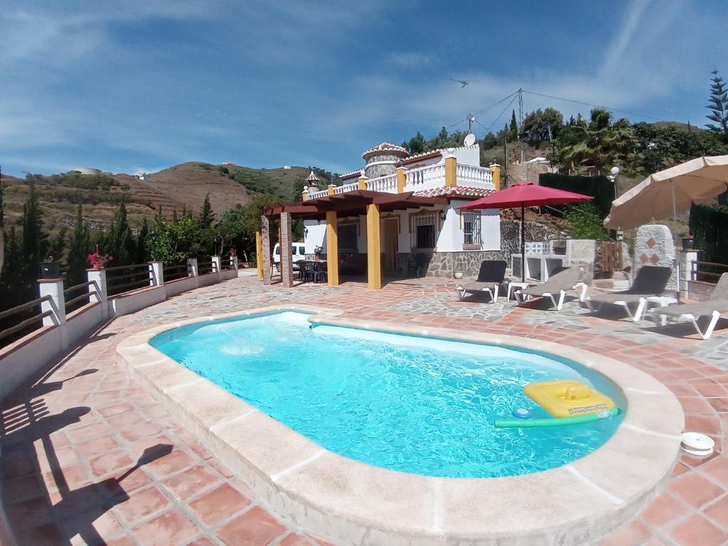 uma piscina num pátio com uma casa em CASA TORRE DEL MANZANO em Torrox Costa