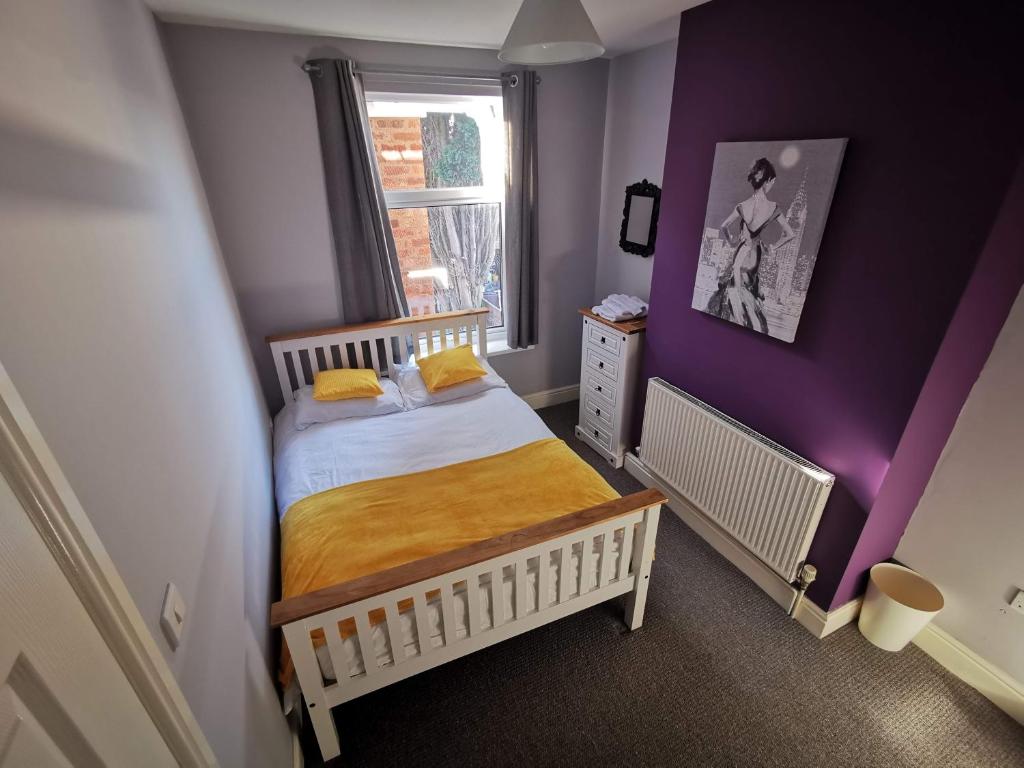 niewielka sypialnia z łóżkiem i oknem w obiekcie K Stunning 5 Bed Sleeps 8 Families Workers by Your Night Inn Group w mieście Wolverhampton