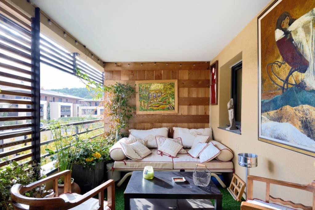 een woonkamer met een bank op een balkon bij Le Précieux terrasse 25m2 et parking privé in Aix-en-Provence