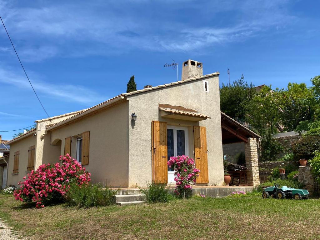 ein kleines Haus mit Blumen davor in der Unterkunft Villa Bel-horizon, soleil du sud in Bagnols-sur-Cèze