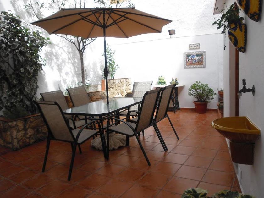 uma mesa e cadeiras com um guarda-sol num pátio em Cal Socías em Vilarrodona