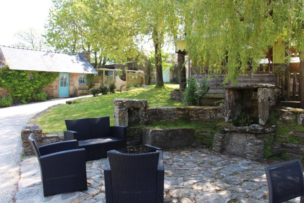 a patio with a couch and chairs in a yard at Auberge de Keringar in Le Conquet