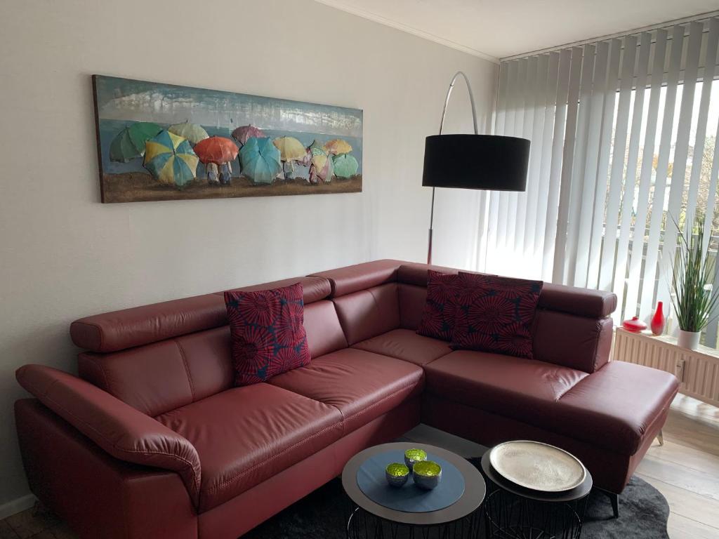 ein Wohnzimmer mit einem braunen Ledersofa in der Unterkunft Apartment Enjoy in Büsum