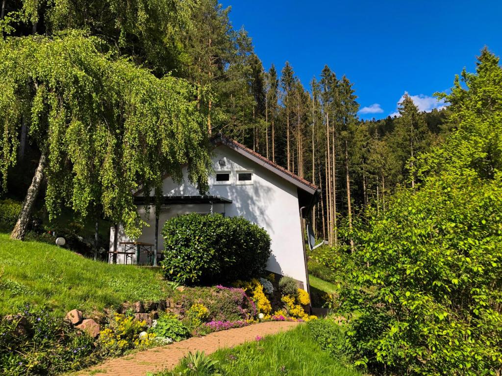 ein weißes Haus inmitten eines Gartens in der Unterkunft Surrbach Chalet in Baiersbronn