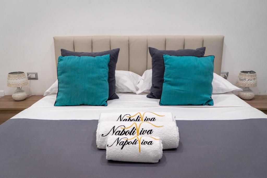ein Schlafzimmer mit einem großen Bett mit blauen Kissen in der Unterkunft Napoliviva Bovio in Neapel