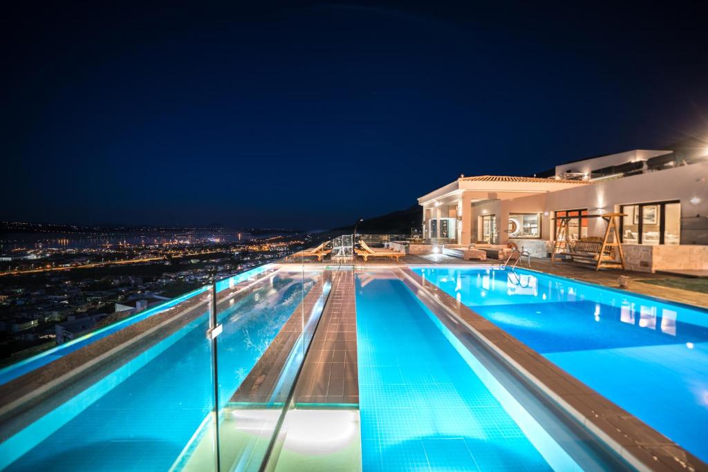 - une vue sur la piscine la nuit dans l'établissement Villa Kedria with a panoramic ocean view, à Souda