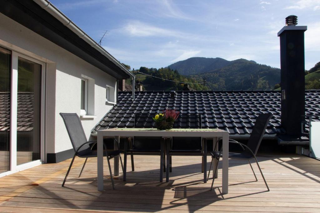 une table et des chaises blanches sur une terrasse avec vue dans l'établissement Köpfchen-Ferienwohnungen – Wohnung Belchen, à Untermünstertal