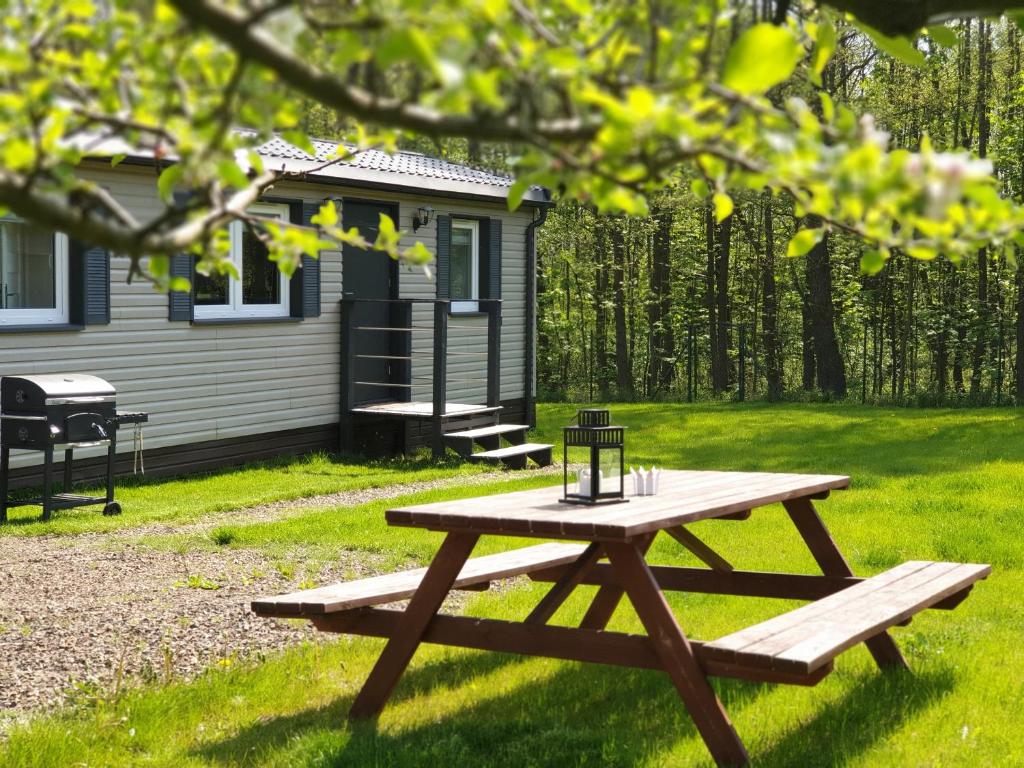 a picnic table in front of a cabin at Odpocznij sobie in Wünschelburg