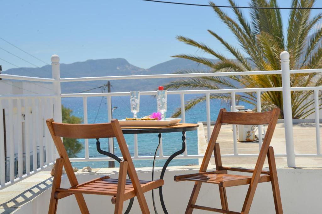 einen Tisch und zwei Stühle auf einem Balkon mit Meerblick in der Unterkunft Esperos Seaside Suite in Adamas, Milos in Adamas