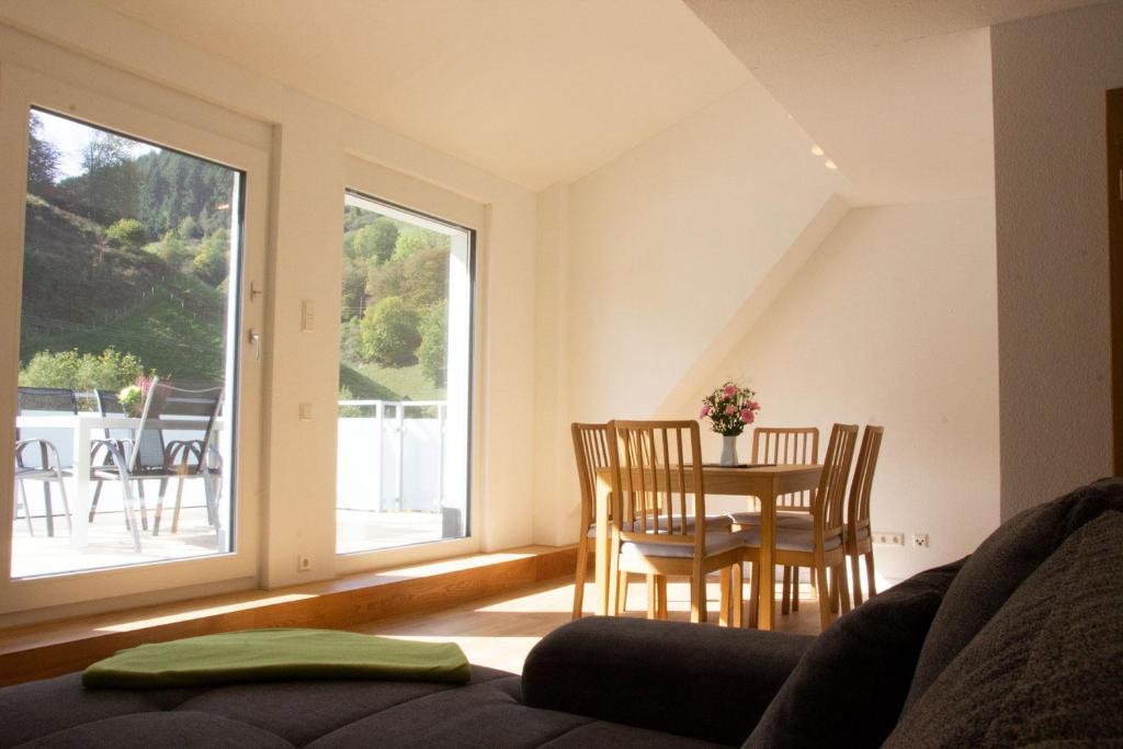 uma sala de estar com uma mesa e cadeiras e uma janela em Köpfchen-Ferienwohnungen – Wohnung Köpfle em Untermünstertal