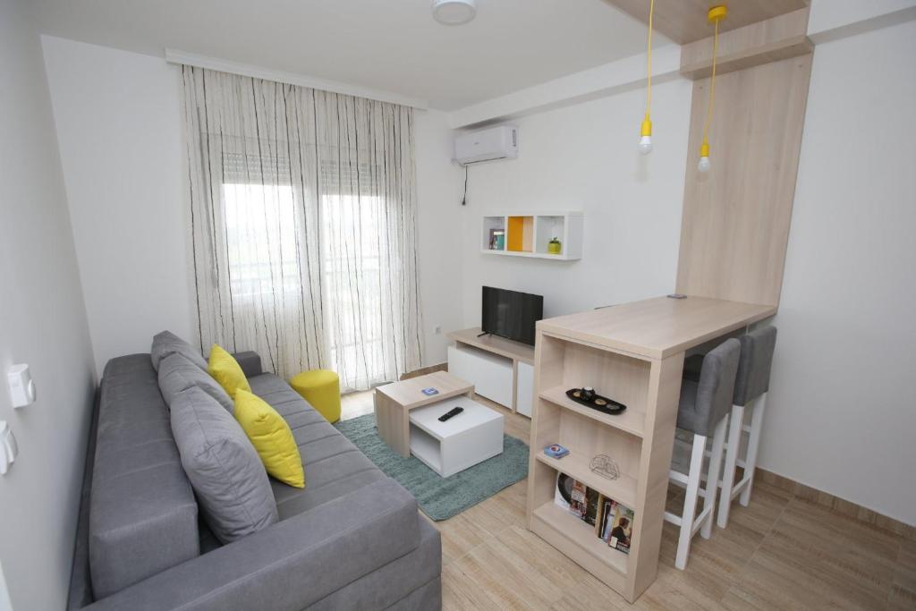 ein Wohnzimmer mit einem grauen Sofa und einem TV in der Unterkunft Fast Sleep & Go 3 in Paraćin