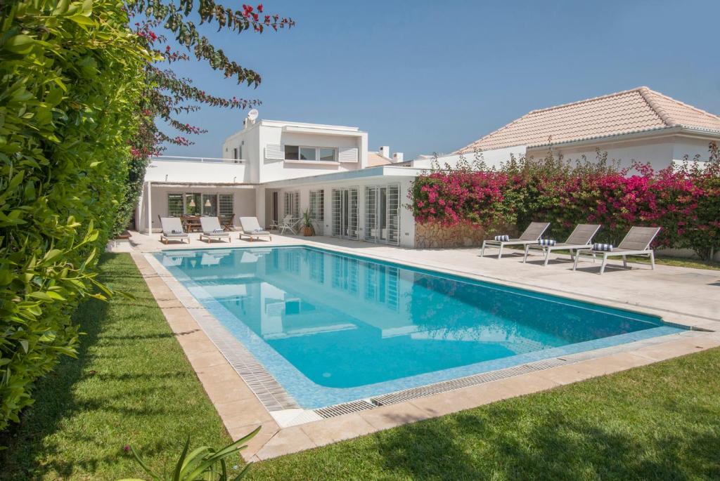 a swimming pool in the backyard of a house at Villa Linda in Aldeia do Meco