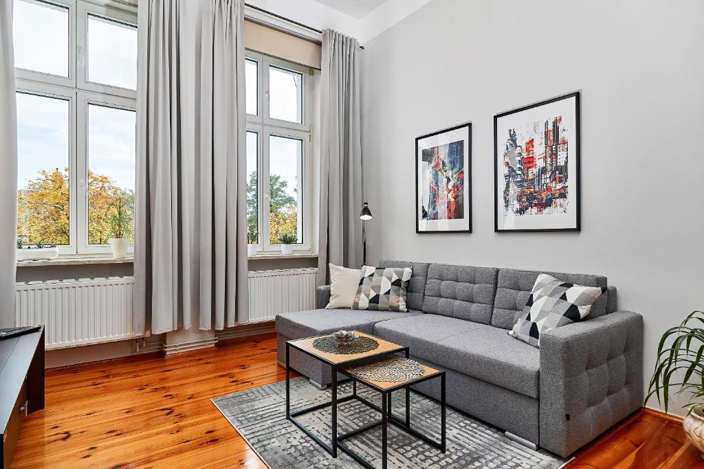 a living room with a couch and two windows at Apartament Nowa 12 in Wrocław