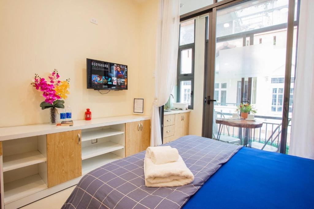 - une chambre avec un lit, un bureau et une fenêtre dans l'établissement Jen & Friends House, à Hô-Chi-Minh-Ville