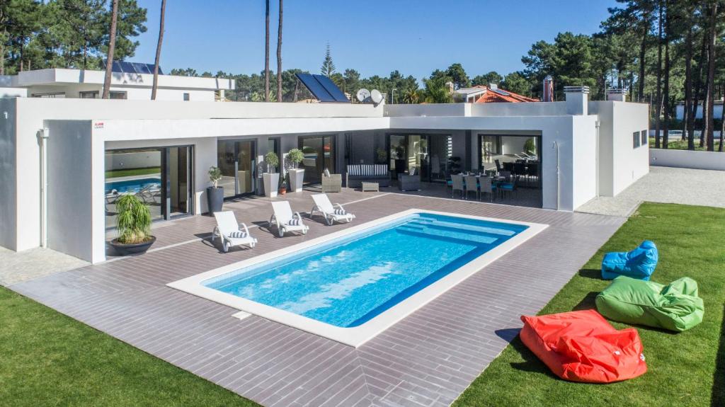 a house with a swimming pool in the backyard at Villa do Moinho II in Carcereiro