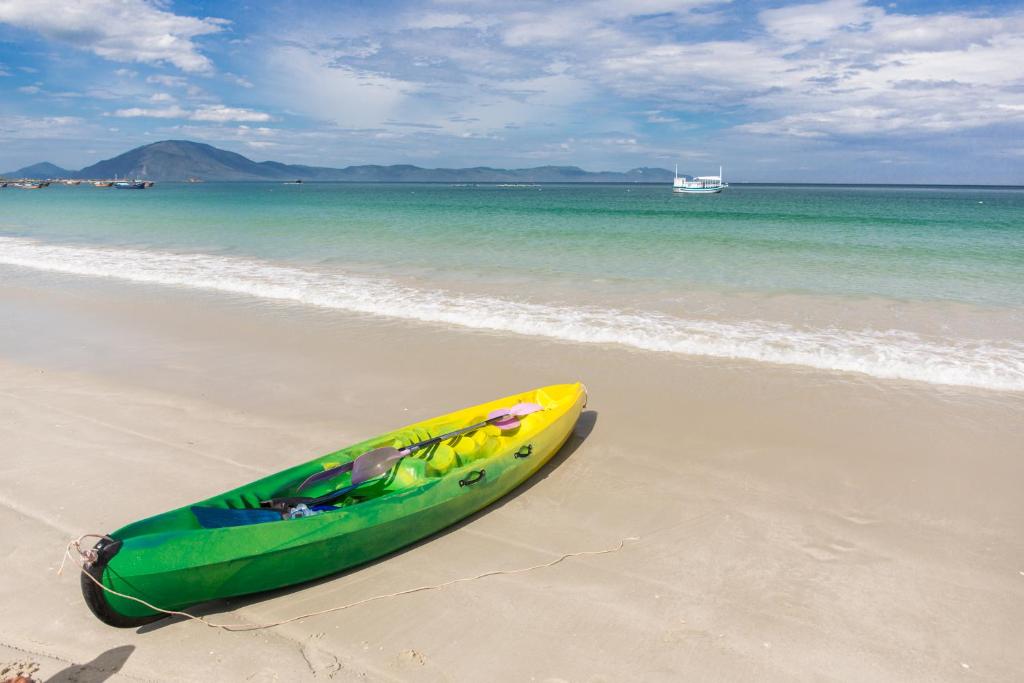 um caiaque verde e amarelo sentado na praia em Paradise Resort Doc Let em Doc Let