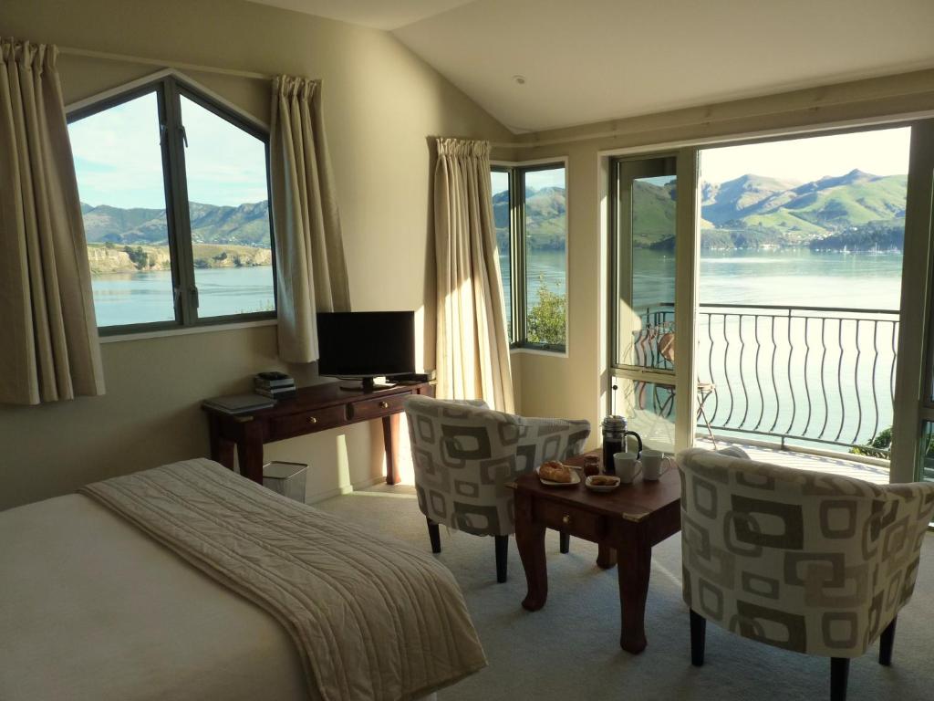 una camera d'albergo con letto, scrivania e finestre di Diamond Harbour Lodge a  Lyttelton