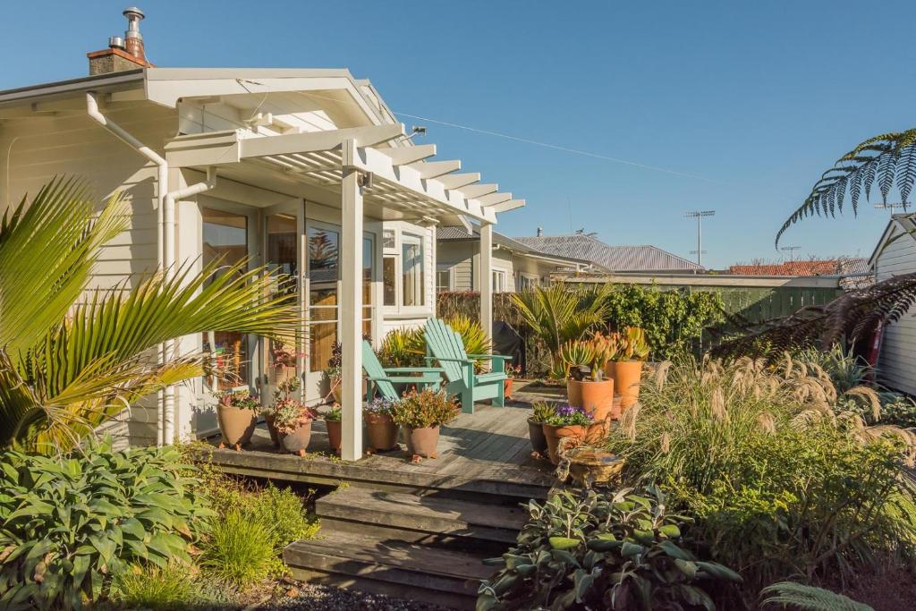 a house with a porch with potted plants on it at Elliott Street Gem in Nelson