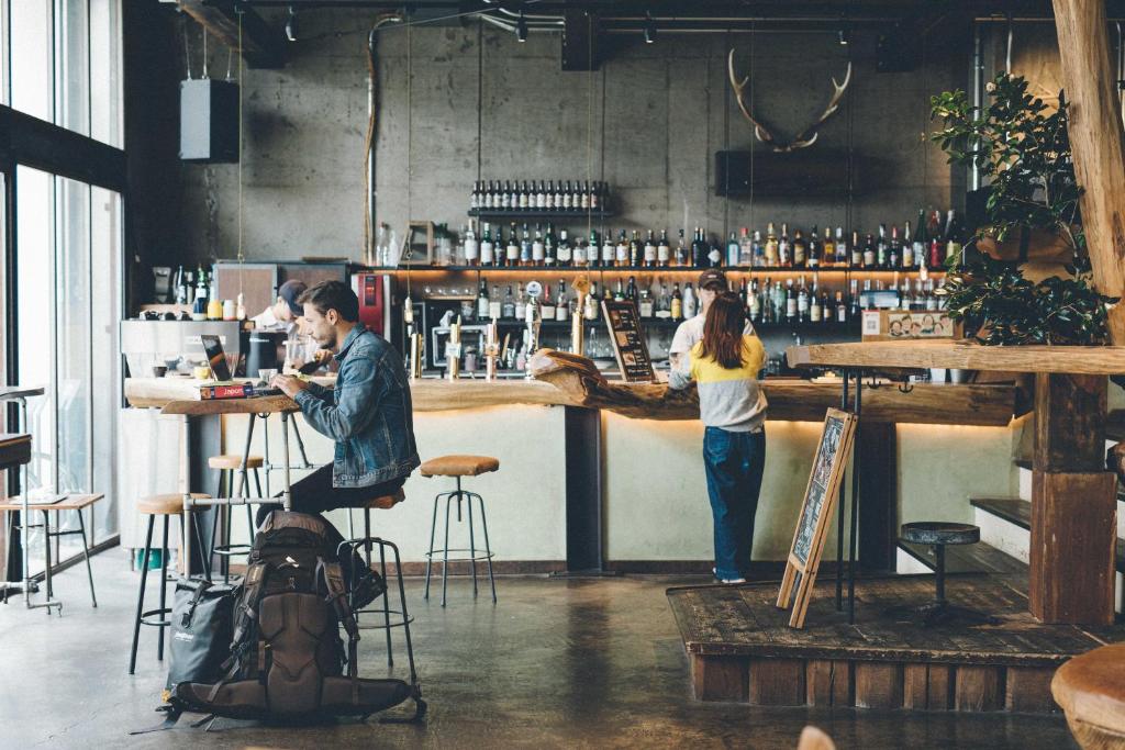 un hombre y una mujer de pie en un bar en Nui. HOSTEL & BAR LOUNGE, en Tokio