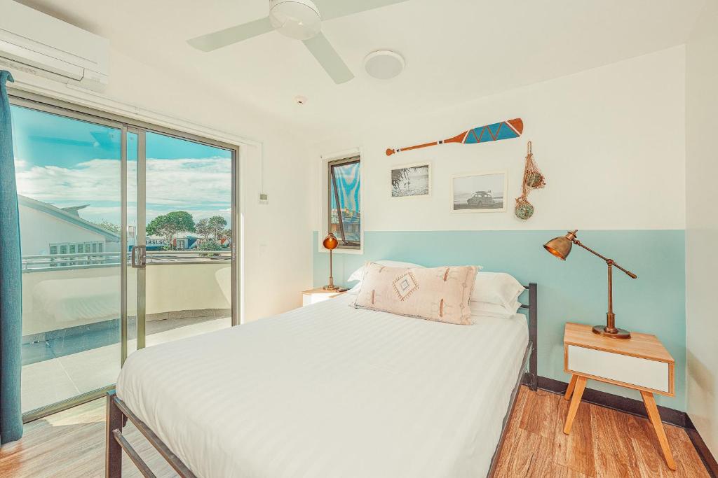 a bedroom with a bed and a window at The Surf House in Byron Bay