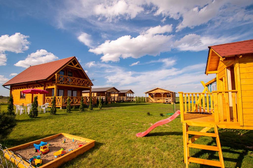 un grupo de cabañas con patio de juegos en Mazurska Przystań, en Giżycko