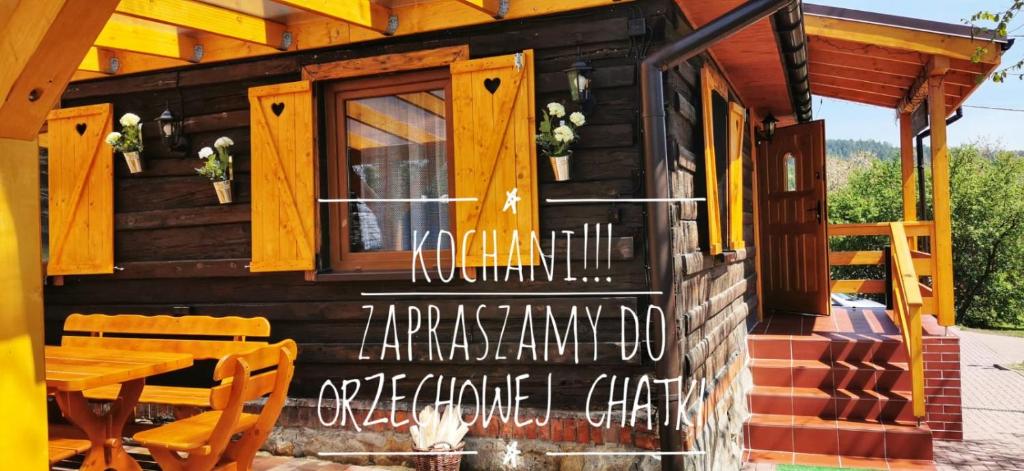 a wooden cabin with a table and a window at Sielanówek - Orzechowa Chatka z sauną wanną termalną jacuzzi in Żywiec