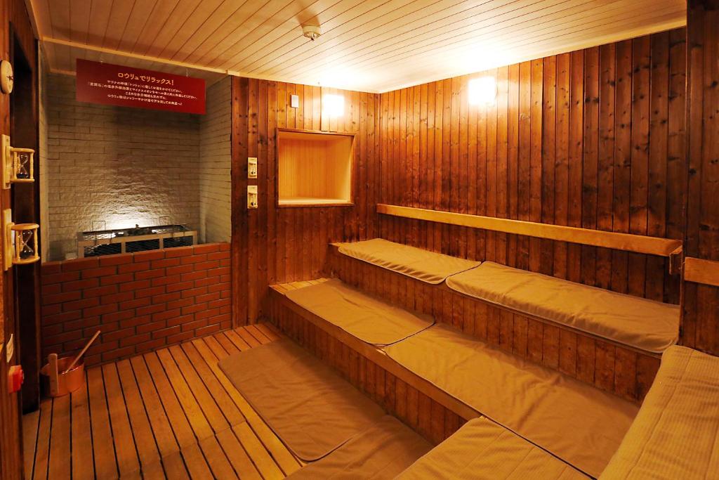 - un sauna avec des murs en bois et des bancs dans une pièce dans l'établissement Kangetsuen, à Otofuke