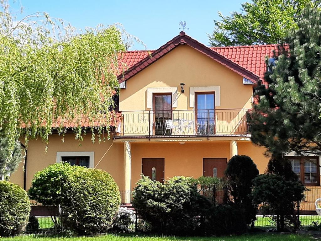 uma grande casa amarela com uma varanda em U Marzeny i Rafała em Sarbinowo