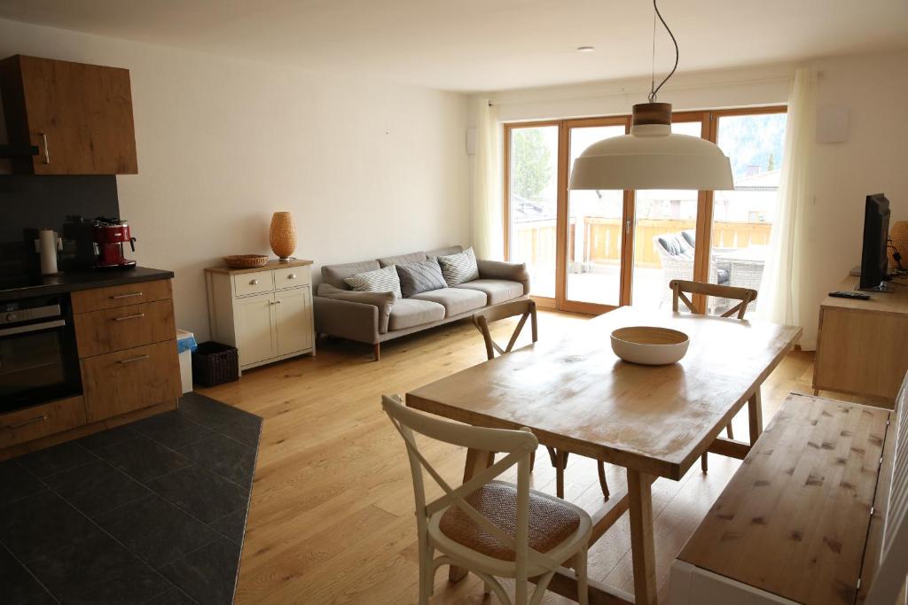 sala de estar con mesa y sofá en Apartment Seeglück am Schliersee - modern, zentral, perfekt für Familien, en Schliersee