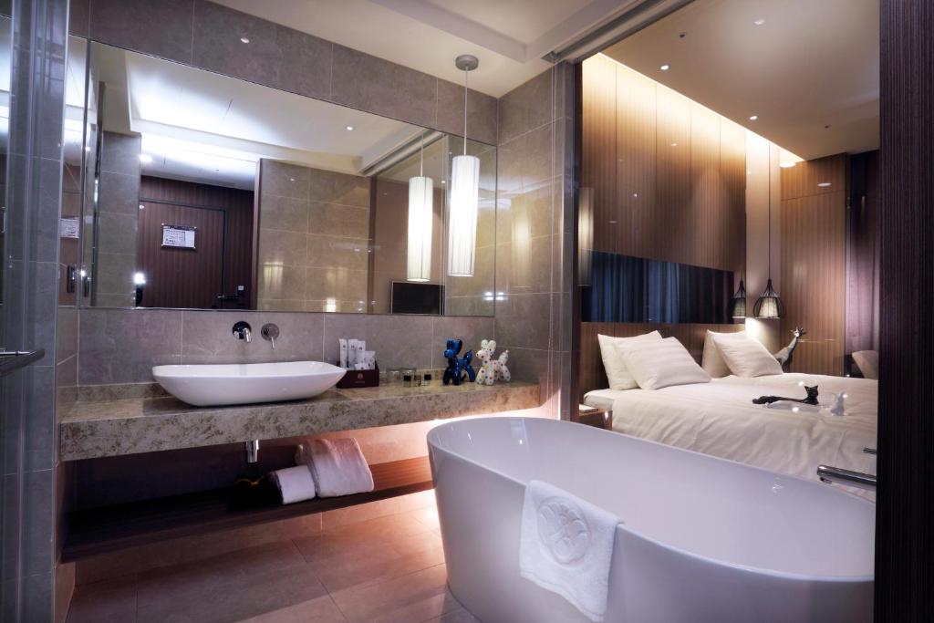a bathroom with a tub and a bed and a sink at Hotel Intrendy in Taishan