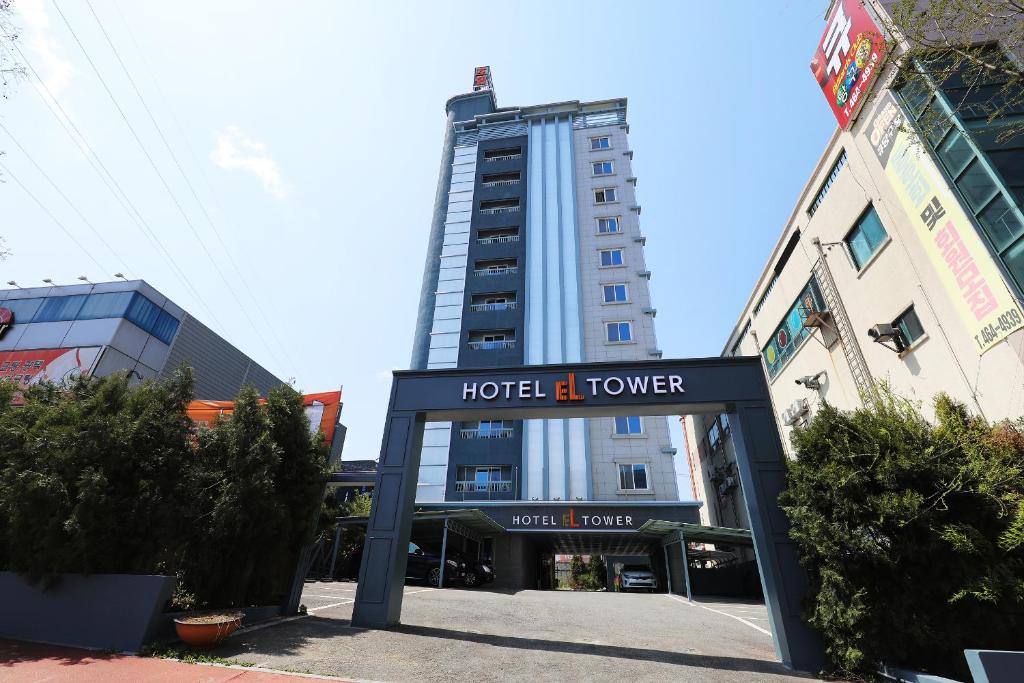 una torre de hotel frente a un edificio en El Tower Hotel en Gunsan