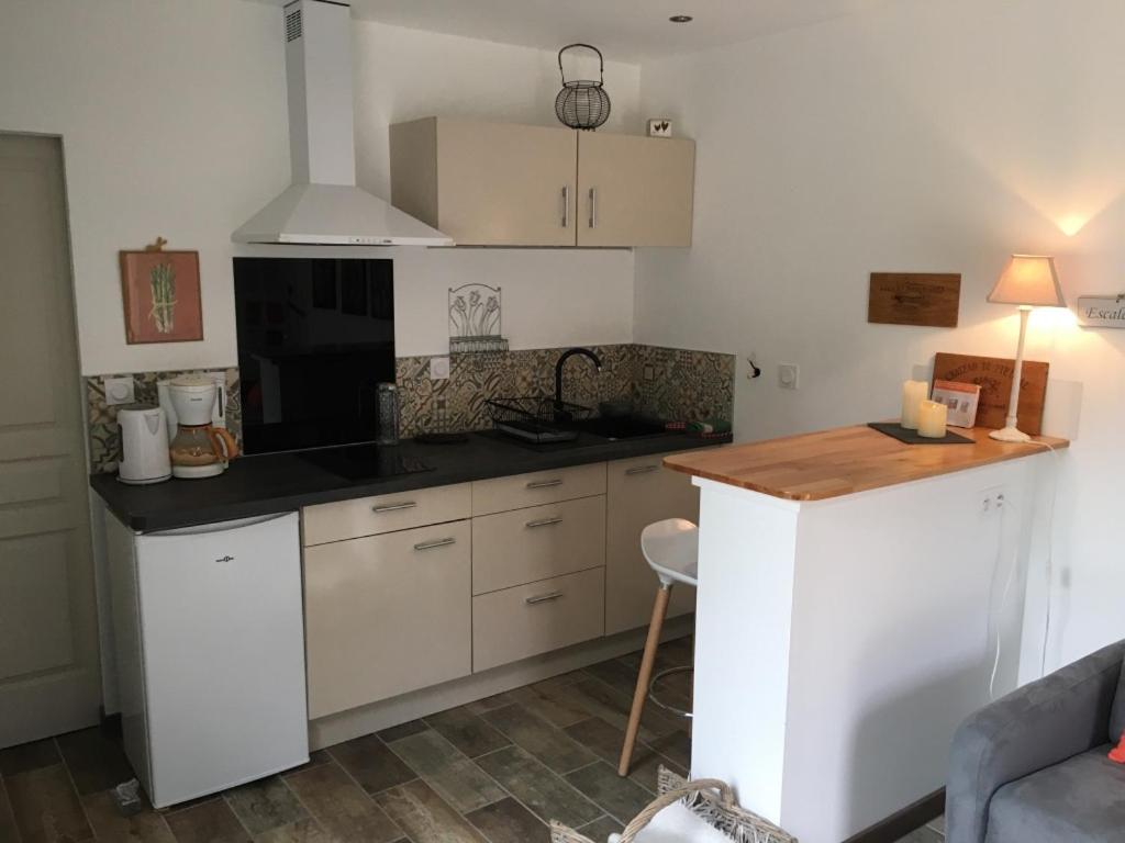 a kitchen with white cabinets and a black counter top at Carpédiem in Sanary-sur-Mer