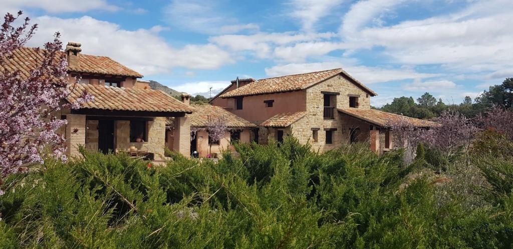 uma fila de velhas casas de pedra num campo em Masia los Toranes - Destino Starlight em Rubielos de Mora