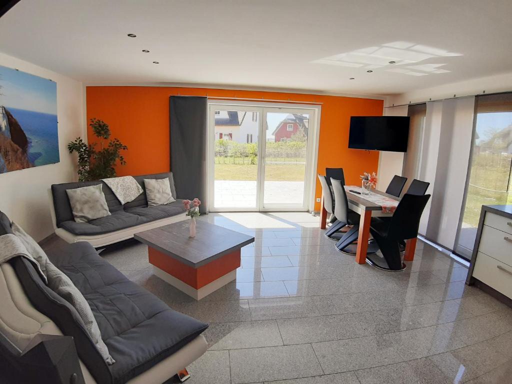 una sala de estar con un sofá y una mesa en Wellenreiter 1, en Breege