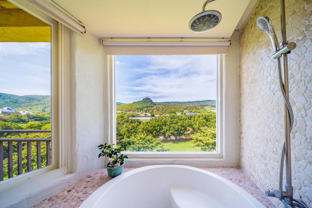 a bath tub in a bathroom with a window at Mong Shan Homestay in Kenting