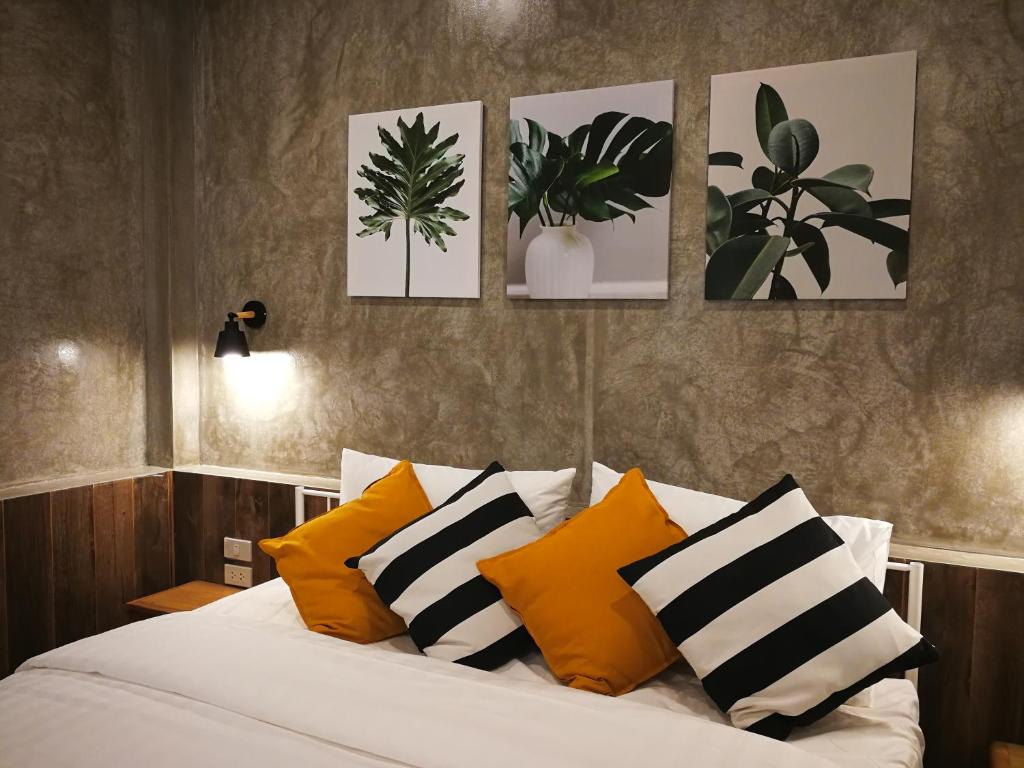 ein Schlafzimmer mit einem Bett mit vier Bildern an der Wand in der Unterkunft baankorrakang in Bangkok Noi