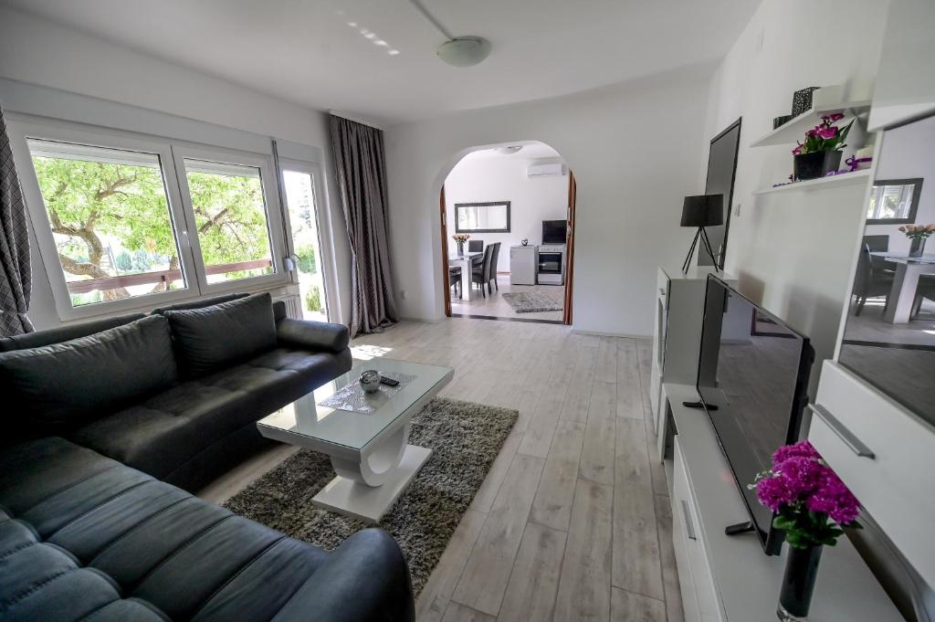 ein Wohnzimmer mit einem Sofa und einem Tisch in der Unterkunft Apartman DORA in Aranđelovac