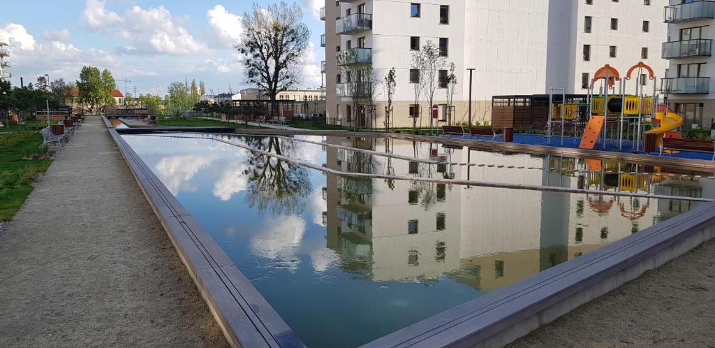 グダニスクにあるApartament Brzeźno Letnicaの遊び場と建物のある水のプール