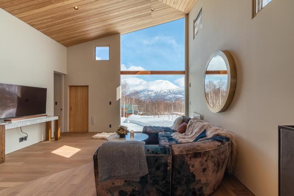 a living room with a couch and a large window at Foxwood D in Niseko
